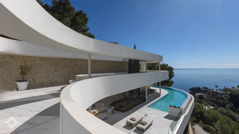 Villa Oleia – Infinity Pool & Sea Views Villa Oleia's modern architecture features a curved infinity pool and multiple terraces overlooking the Mediterranean Sea in Jávea.