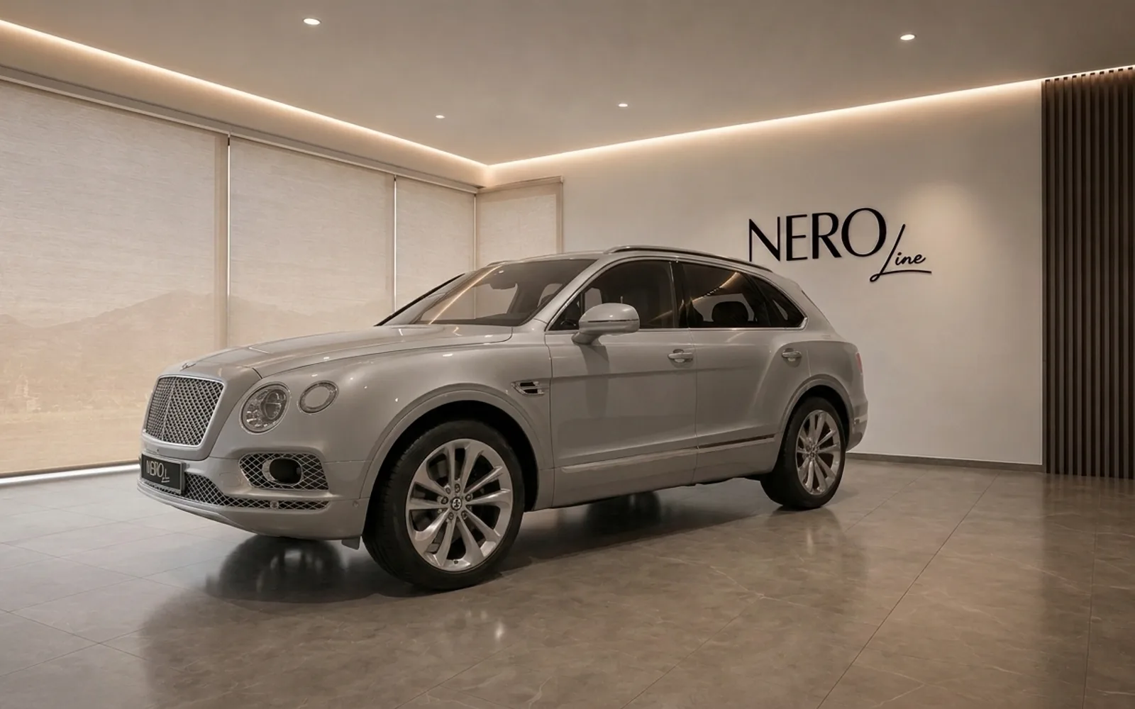 A sleek Gloss Silver Bentley Bentayga V8 is elegantly displayed in a modern showroom in Lausanne, featuring the NEROline logo.