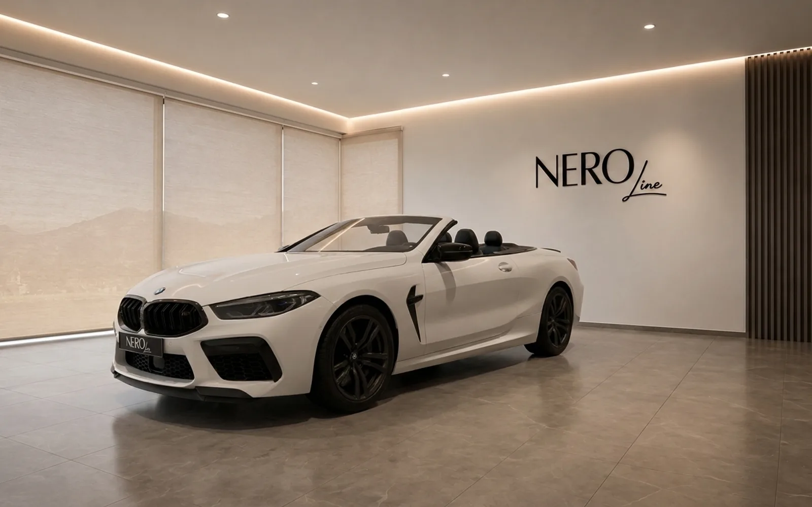 The white BMW M8 Competition Cabriolet is showcased in a modern showroom in Lausanne, featuring its sleek front three-quarter view with the top down.