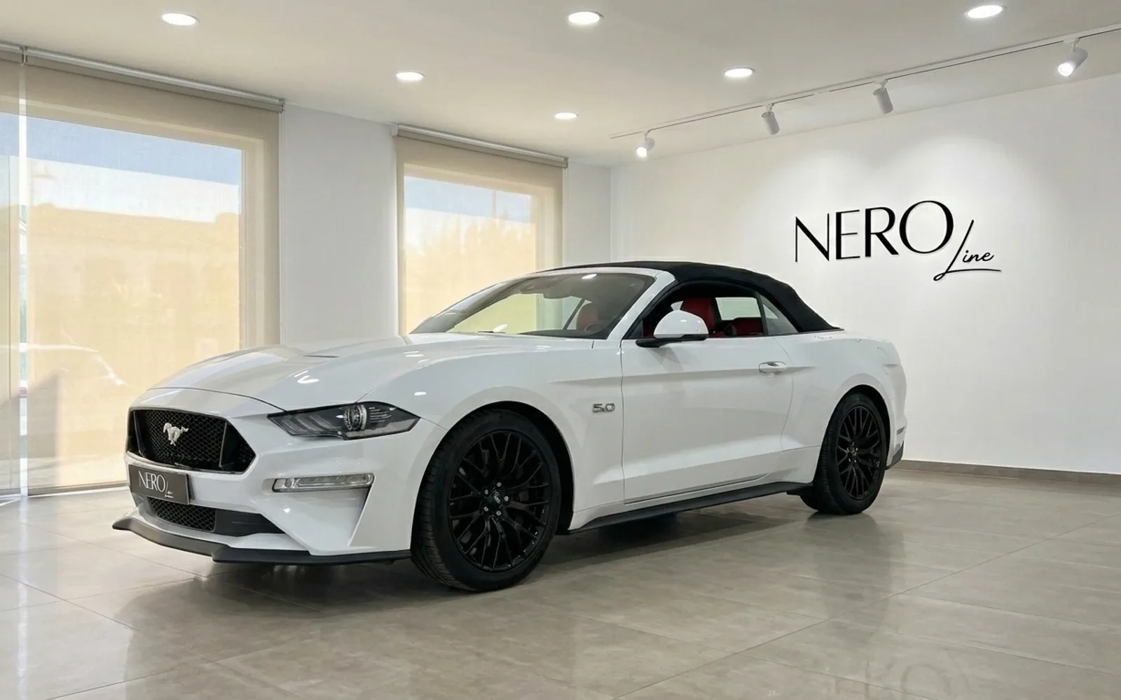 Ford Mustang GT Convertible — Vista frontal tres cuartos, Alicante Ford Mustang GT Convertible blanco con capota negra e interior rojo, visto de frente tres cuartos en el interior en Alicante.
