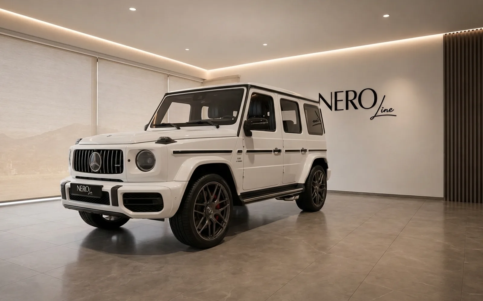 The white Mercedes-Benz G63 AMG is showcased from a front three-quarter angle inside a modern showroom in Lausanne.