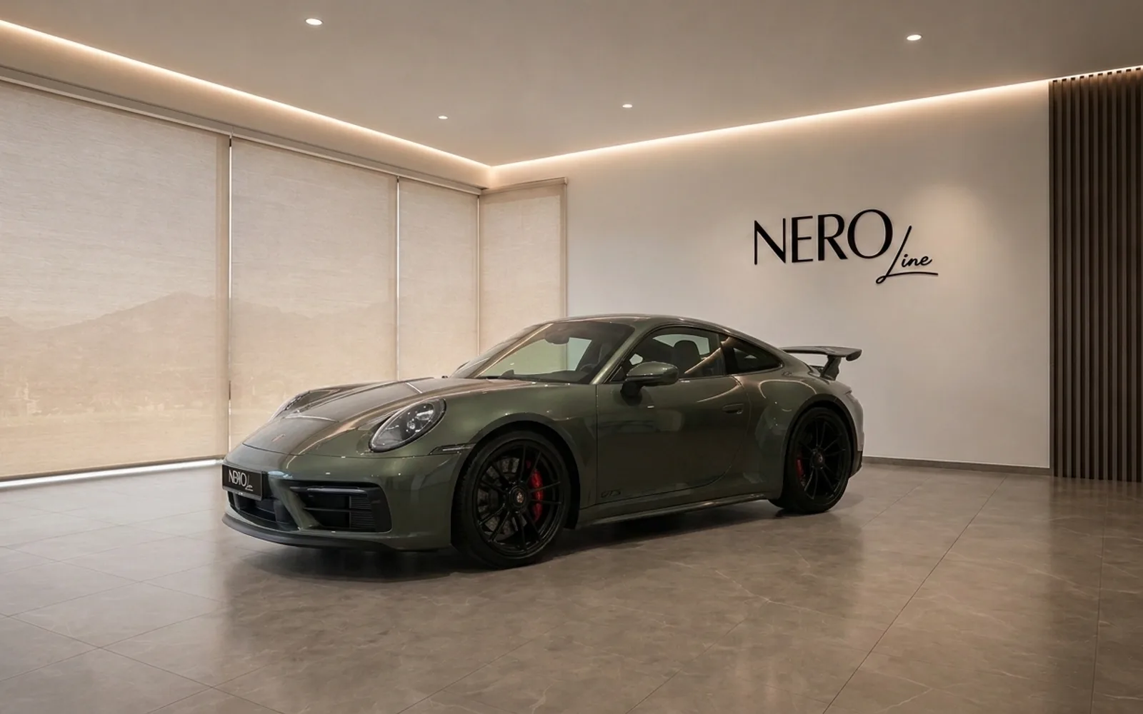 Porsche 911 Carrera 4 GTS Aerokit — Showroom View The gloss Aventurine Green Metallic Porsche 911 Carrera 4 GTS Aerokit is showcased from a front three-quarter view in a modern Zurich showroom.