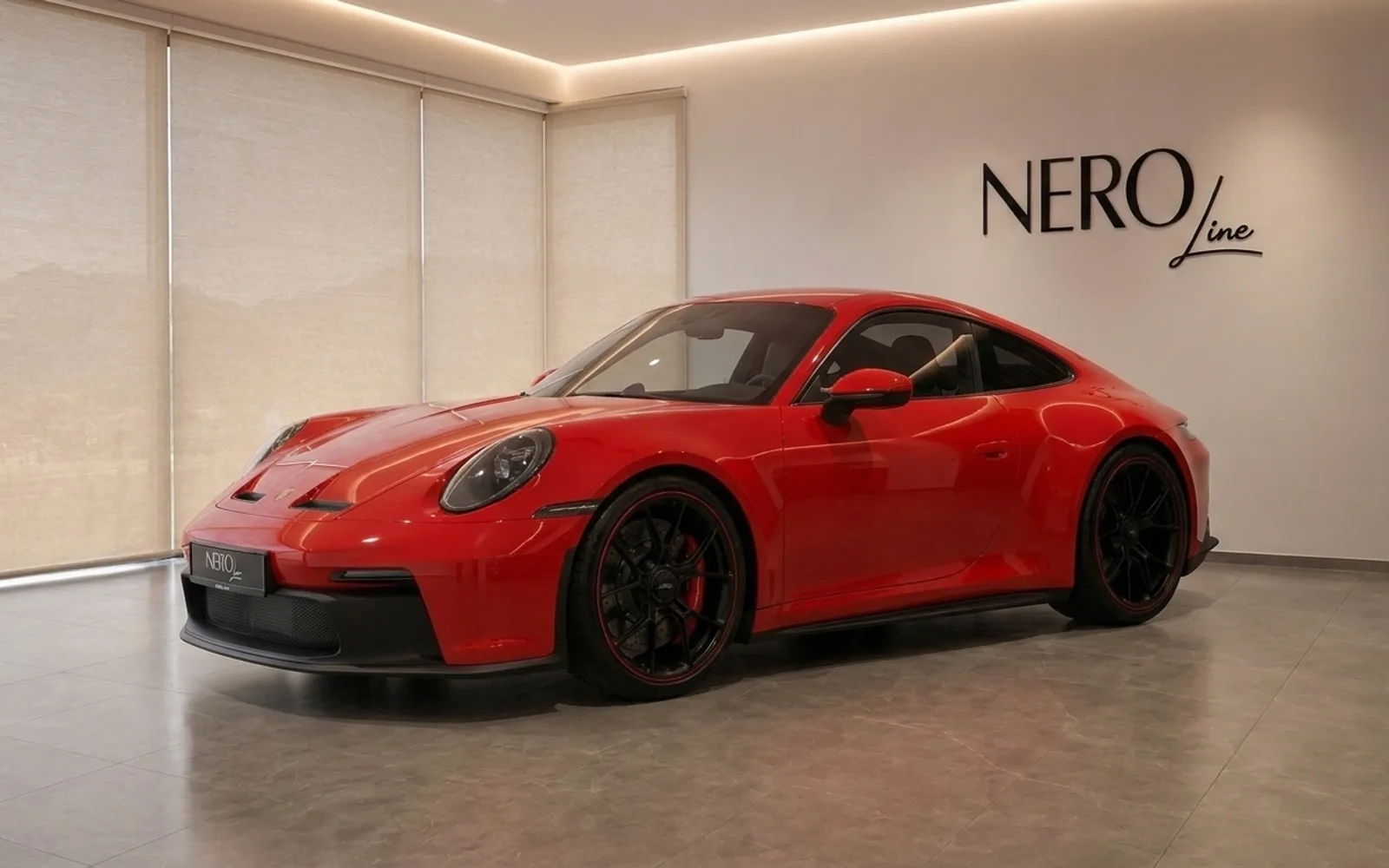 The red Porsche 911 GT3 Touring is showcased from a front three-quarter view in a modern showroom in Zurich.
