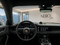 The Porsche GT3 RS cockpit interior showcases the steering wheel, dashboard, and infotainment screen, with Swiss Alps visible in Zurich.
