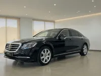 The gloss black Mercedes-Benz S 600 L GUARD is parked at a slight angle in a modern showroom in Zurich.