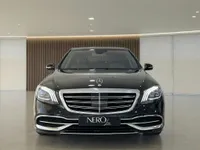 The front view of a glossy black Mercedes-Benz S 600 L GUARD armored car, parked in a modern showroom in Zurich.