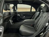 The luxurious rear interior of the Mercedes-Benz S 600 L GUARD in Zurich, featuring black leather seats and infotainment screens.
