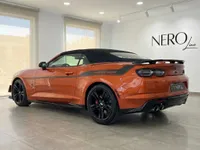 Un Chevrolet Camaro Cabriolet 6.2 naranja metálico brillante, con capota negra y calcomanía "THS DESIGN", estacionado en Alicante.