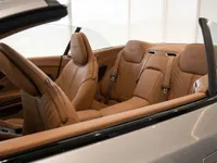 The luxurious tan leather interior, showcasing the front and rear seats of the Aston Martin DB12 Volante in Lausanne.