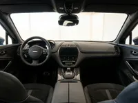 The luxurious interior of the Aston Martin DBX707 in Lausanne, showcasing the dashboard, steering wheel, and front seats.