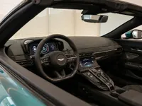 The luxurious interior cockpit of the Aston Martin Vantage in Lausanne, featuring the steering wheel, digital dashboard, and central console.