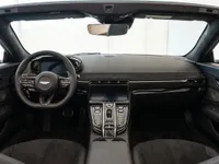 The luxurious interior of the Aston Martin Vantage V8 Roadster in Lausanne, featuring its steering wheel, dashboard, and central console.