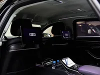 The luxurious rear interior of the Audi A8 L VR10 Armoured in Madrid, featuring dual infotainment screens and ambient lighting.