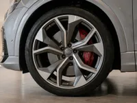 The front wheel of the 2022 Audi RS Q8 in Gloss metallic Florett Silver Metallic, showcasing its distinctive rim and red brake caliper in Lausanne.