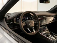 The luxurious cockpit of the 2022 Audi RS Q8 in Lausanne, showcasing the sporty steering wheel, digital displays, and premium carbon fiber trim.
