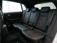 The luxurious black leather rear seats with distinctive red honeycomb stitching and RS logo of the Audi RS Q8 in Lausanne.