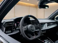 The luxurious interior of the 2023 Audi RS3 Performance Edition in Zurich, showcasing its sporty steering wheel and advanced digital cockpit.