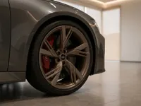 The front wheel of the Audi RS6 Avant Performance in Lausanne, featuring a bronze multi-spoke rim and a vibrant red brake caliper.