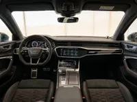 The luxurious interior cockpit of the 2023 Audi RS6 Avant Performance in Lausanne, featuring a digital dashboard, dual touchscreens, and sport seats with red stitching.