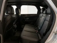 The luxurious black leather rear interior of the Bentley Bentayga V8, featuring wood trim and ample seating in Lausanne.