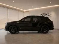 A sleek black Bentley Bentayga V8 is parked indoors, showcasing its elegant side profile in Zurich.