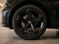 Close-up of the glossy black front wheel and Pirelli P Zero tire on the Bentley Bentayga V8 in Zurich.