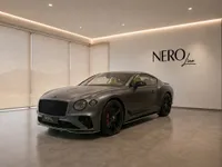 The 2022 Bentley Continental GT in Satin Anthracite Grey, showcasing its front three-quarter view in a modern Lausanne showroom.