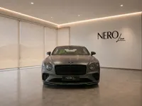 Bentley Continental GT in Satin Anthracite Grey, with green interior, displayed front-on in a NEROline showroom in Lausanne.