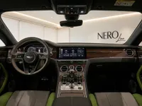 The luxurious interior of the Bentley Continental GT features a detailed dashboard, steering wheel, and infotainment screen in Lausanne.