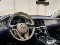The luxurious interior of the Bentley Flying Spur, showcasing the elegant dashboard, steering wheel, and infotainment system in Lausanne.