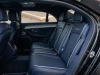 The luxurious rear interior of the 2023 Bentley Flying Spur, showcasing dark blue leather seats with white stitching in Lausanne.