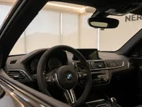 The luxurious interior of the BMW M2 CS in Zurich, featuring its sporty steering wheel and detailed dashboard.