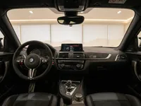 The luxurious interior cockpit of the BMW M2 CS in Zurich, showcasing the steering wheel, dashboard, and infotainment system.
