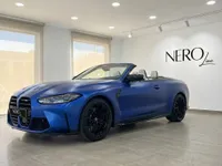 El BMW M4 Competition Cabrio 2023 en azul Frozen Portimao mate, descapotado, se exhibe en un luminoso showroom de Ibiza.