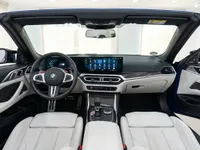 El lujoso habitáculo interior del BMW M4 Competition Cabrio en Ibiza, con asientos de cuero blanco y un salpicadero moderno.