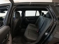 The luxurious black leather interior of the 2025 BMW M5 Touring, showing the rear passenger seats and a glimpse of the front dashboard in Zurich.