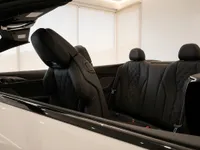 The luxurious black leather interior of the BMW M8 Competition Cabriolet, showing the front passenger and rear seats, in Lausanne.