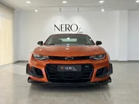 Vista frontal del Chevrolet Camaro Cabriolet 6.2 naranja metálico brillante, aparcado en un concesionario en Alicante, España.