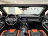 El interior del Chevrolet Camaro Cabriolet 6.2 presenta un salpicadero negro con asientos y volante con detalles naranjas, visible en Alicante.