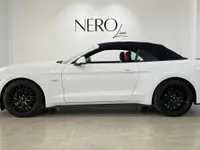 El Ford Mustang GT 5.0 V8 Convertible blanco con su capota blanda negra se muestra de perfil en Alicante.