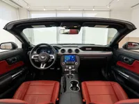 El interior del Ford Mustang GT Convertible en Alicante, con salpicadero negro, pantalla táctil central y llamativos asientos de cuero rojo.