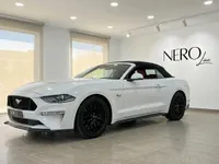 Ford Mustang GT Convertible blanco con capota negra e interior rojo, visto de frente tres cuartos en el interior en Alicante.