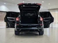 黒いBMW X5 M装甲SUVが、マドリードのショールームで全てのドアとトランクを開けた状態で後方から写されています。