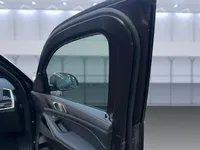 マドリードのBMW X5 Mアーマードの開いたフロントドア。厚い装甲フレーム、着色窓、豪華な革製インテリアパネルが特徴です。