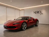The gloss Rosso Imola metallic red Ferrari 296 GTB is parked in a modern showroom in Lausanne, showcasing its elegant front three-quarter view.
