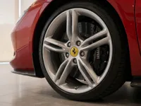 Close-up of the Ferrari 296 GTB's front wheel, showcasing the silver multi-spoke rim, yellow Ferrari emblem, and black brake caliper in Lausanne.