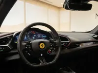 The luxurious cockpit of the Ferrari 296 GTB in Lausanne, featuring its advanced digital dashboard and multi-function steering wheel.