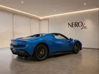 The stunning blue Ferrari 296 GTS is showcased from a rear three-quarter angle in a modern NEROline showroom in Lausanne.