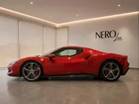 The red Ferrari 296 GTS is showcased from its sleek side profile in a luxurious Zurich showroom.