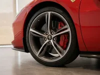 The red Ferrari 296 GTS's front wheel, showcasing its elegant rim and bright red brake caliper, in Zurich.